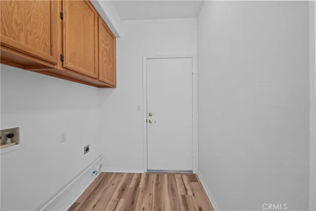 a view of a storage and utility room with wooden floor