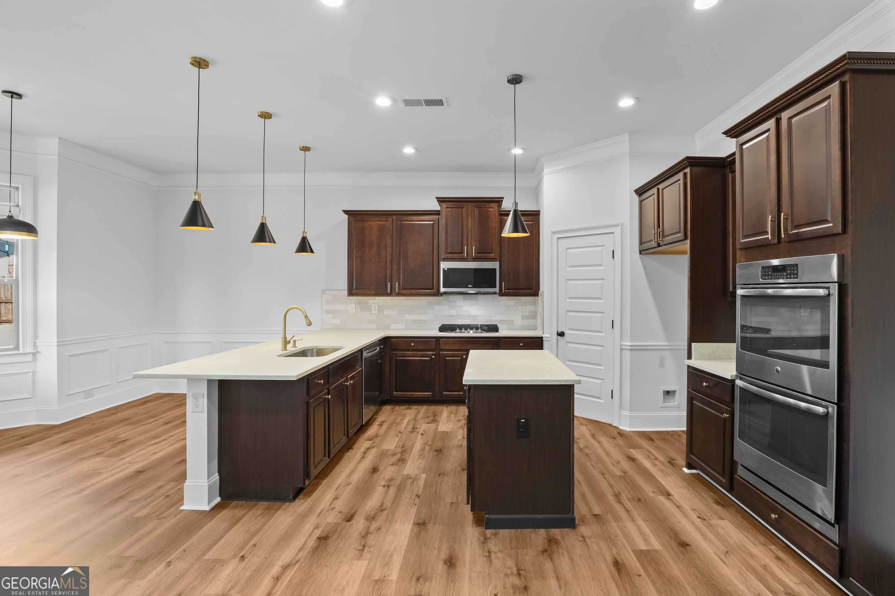 200 Snow Bird Drive Hampton, GA 30228 - Photo 12 of 55 a large kitchen with stainless steel appliances kitchen island granite countertop a stove a sink dishwasher a refrigerator and a oven with wooden floor