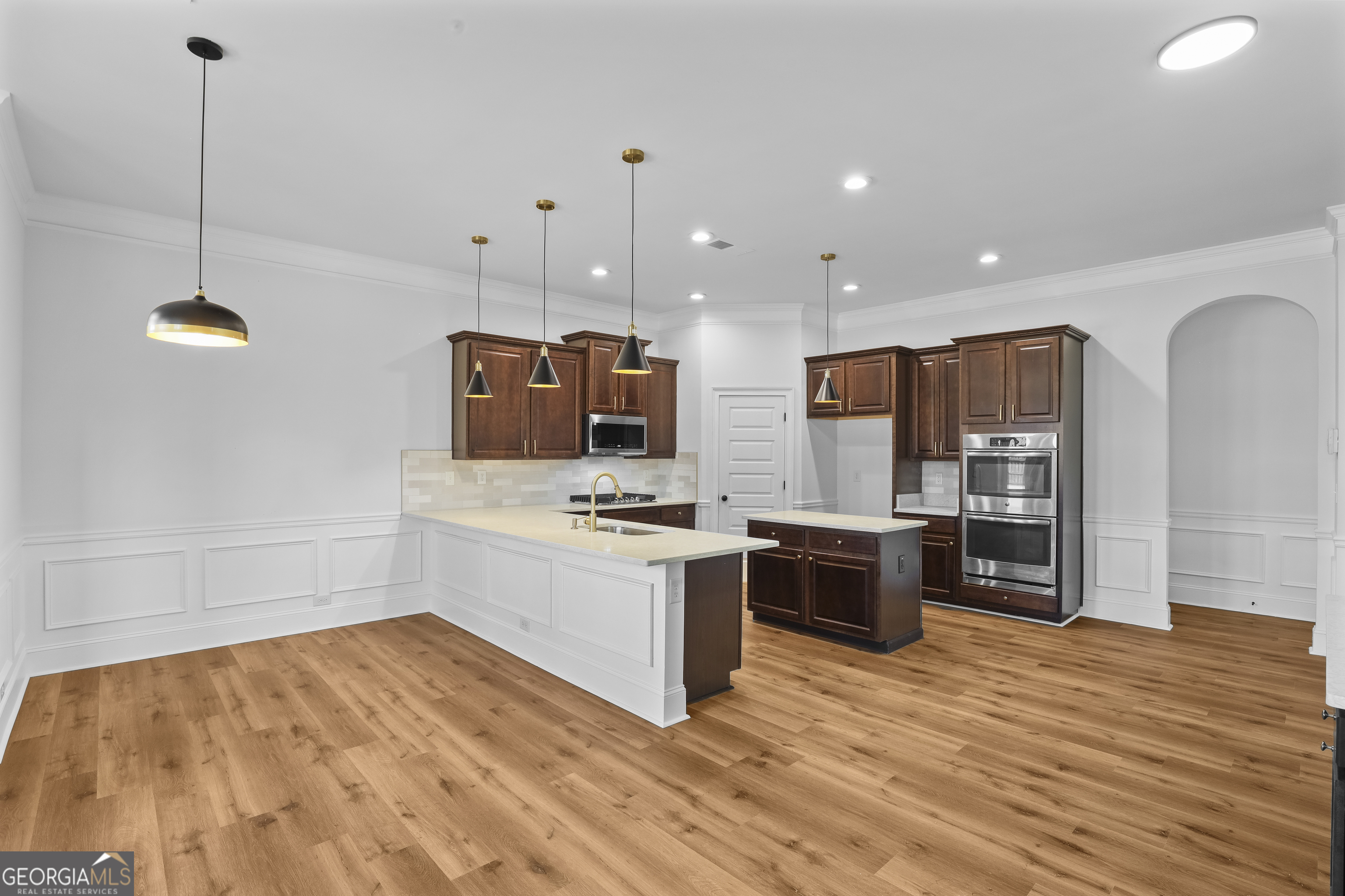 200 Snow Bird Drive Hampton, GA 30228 - Photo 17 of 55 a kitchen with stainless steel appliances a stove top oven a sink dishwasher a refrigerator and a dining table with wooden floor