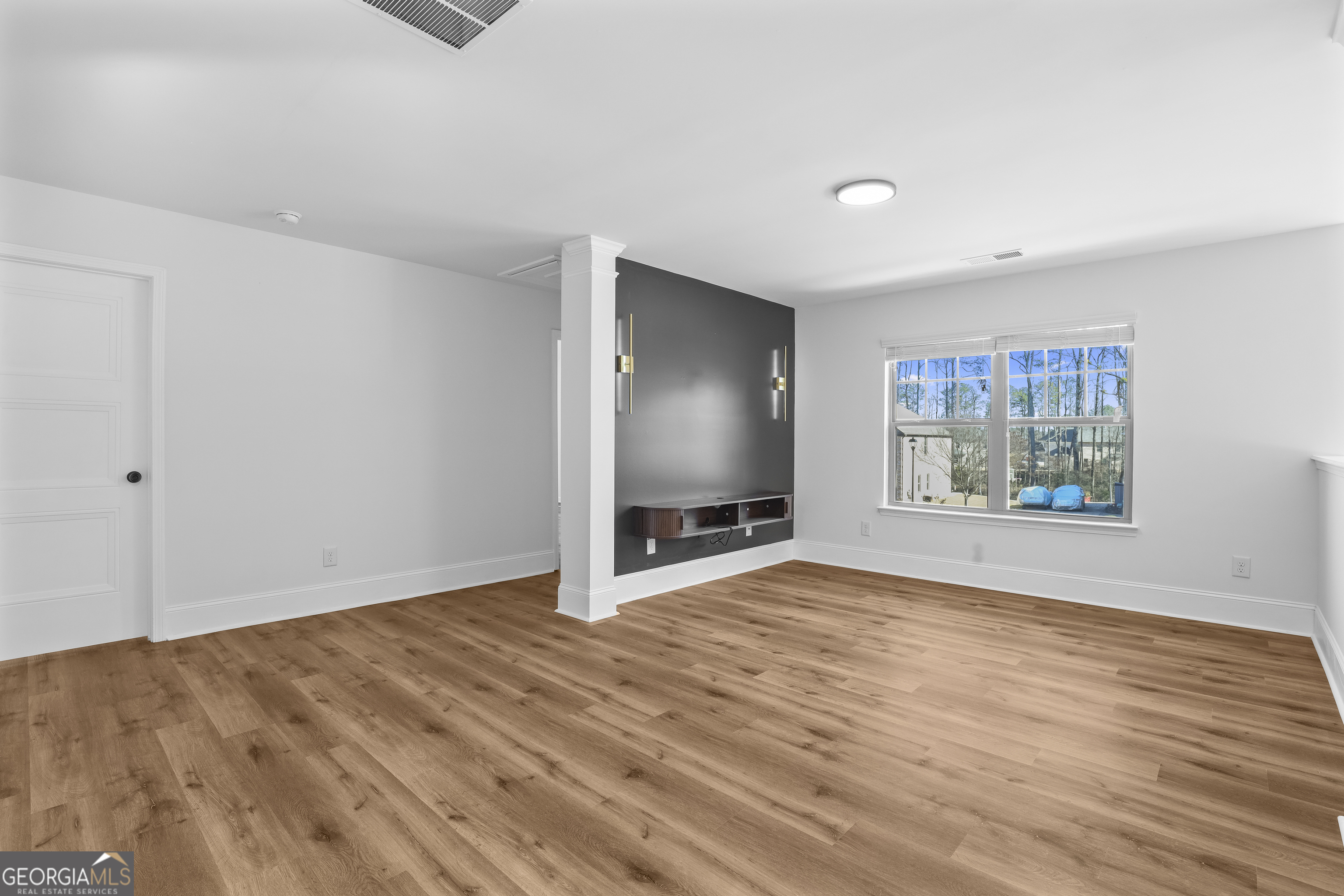 200 Snow Bird Drive Hampton, GA 30228 - Photo 22 of 55 a view of an empty room with wooden floor and a window