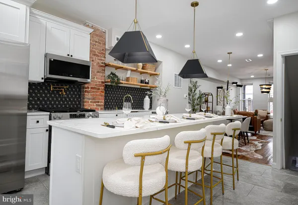 a kitchen with stainless steel appliances kitchen island granite countertop a sink and a stove