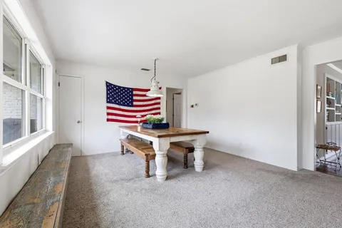 a view of a workspace with furniture and a window