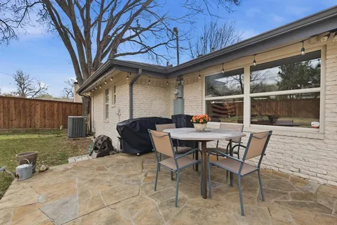 a backyard of a house with table and chairs