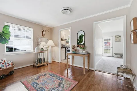 a living room with furniture and a wooden floor