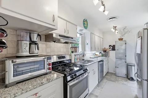 a kitchen with stainless steel appliances a stove a refrigerator and cabinets