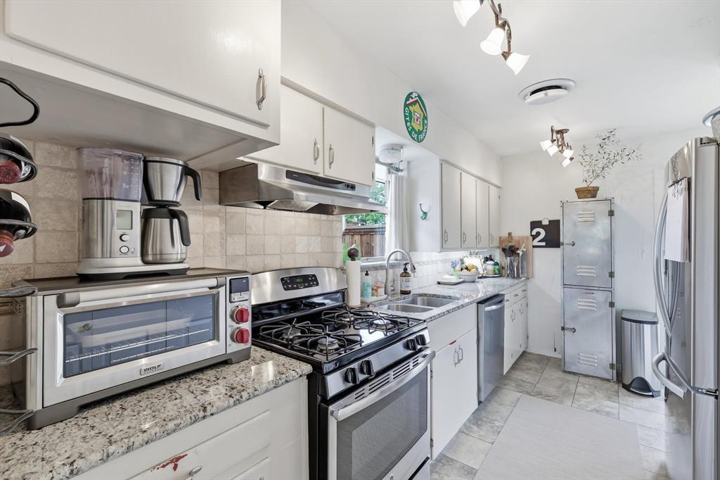 10029 Shadyview Drive Dallas, TX 75238 - Photo 8 of 30 a kitchen with stainless steel appliances a stove a refrigerator and cabinets