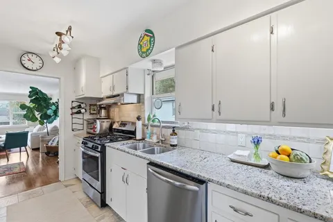 a kitchen with stainless steel appliances granite countertop a sink a stove and cabinets