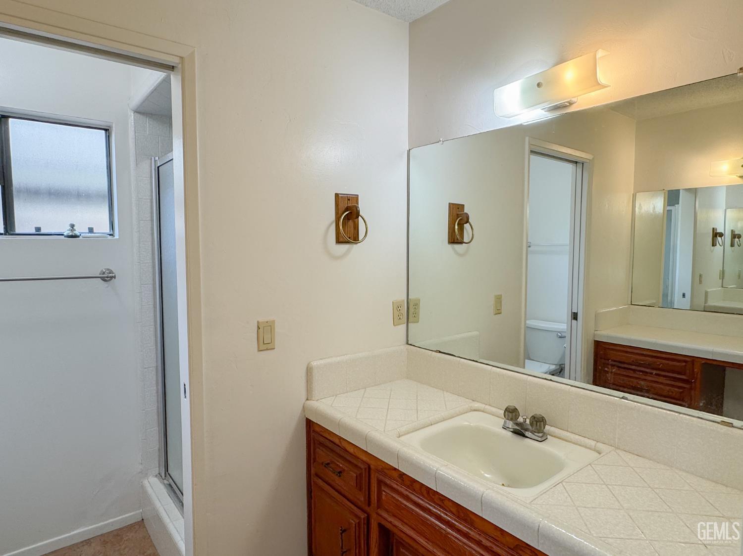 Undisclosed Address Bakersfield, CA 93309 - Photo 26 of 38 a bathroom with a sink vanity and mirror