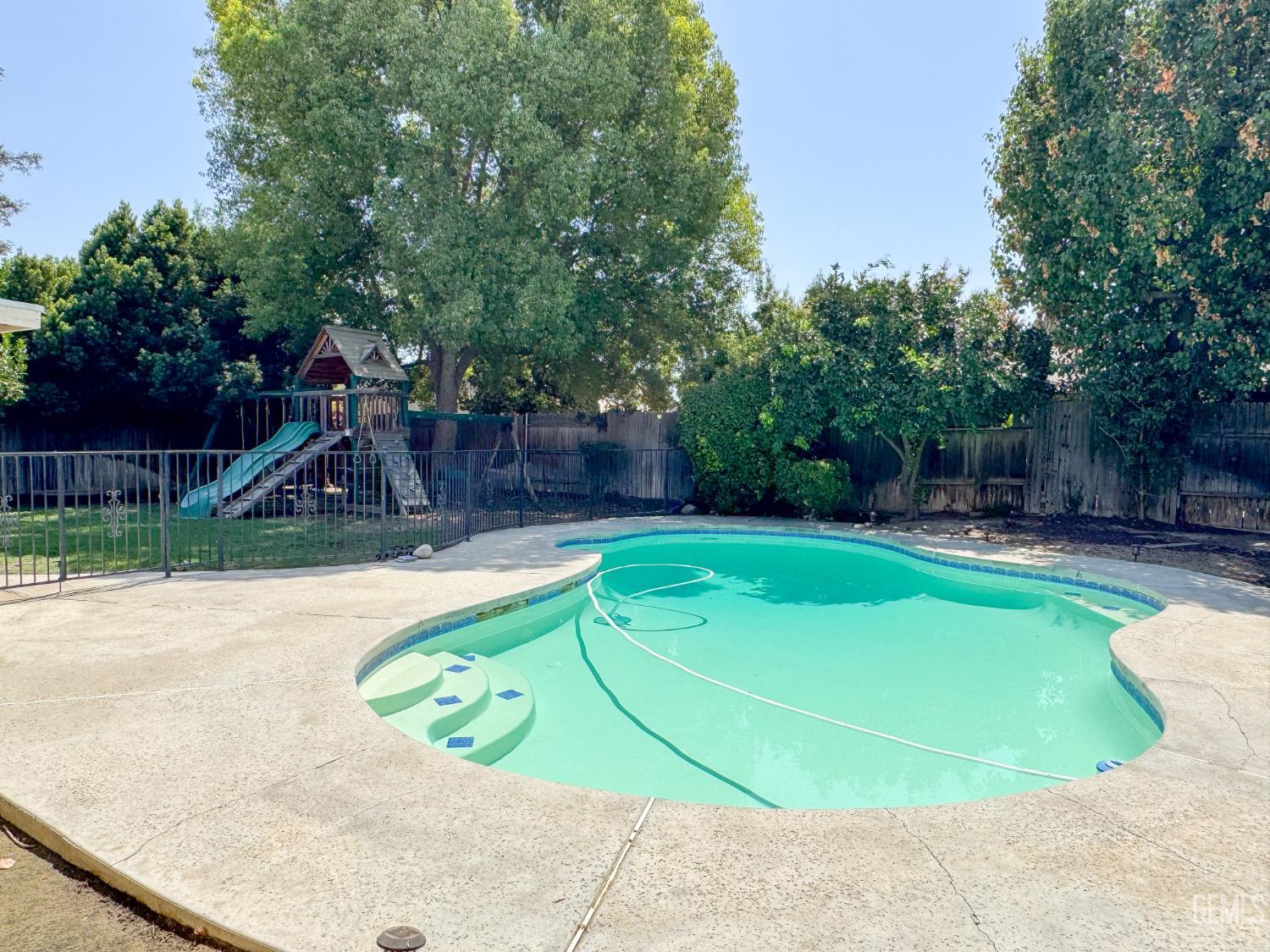 Undisclosed Address Bakersfield, CA 93309 - Photo 35 of 38 a view of a swimming pool with a patio and a yard