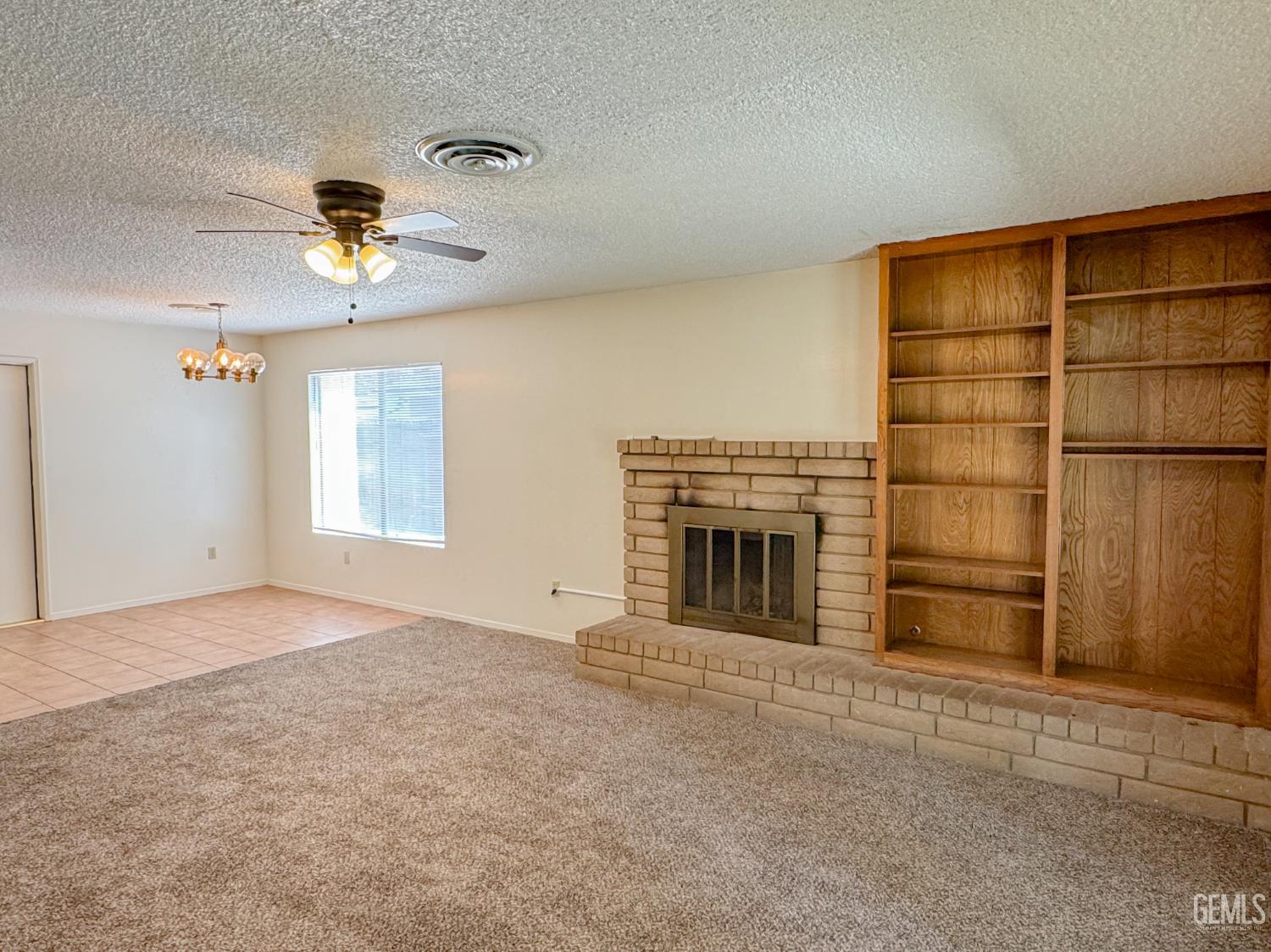 Undisclosed Address Bakersfield, CA 93309 - Photo 8 of 38 a view of an empty room with a fireplace and a window