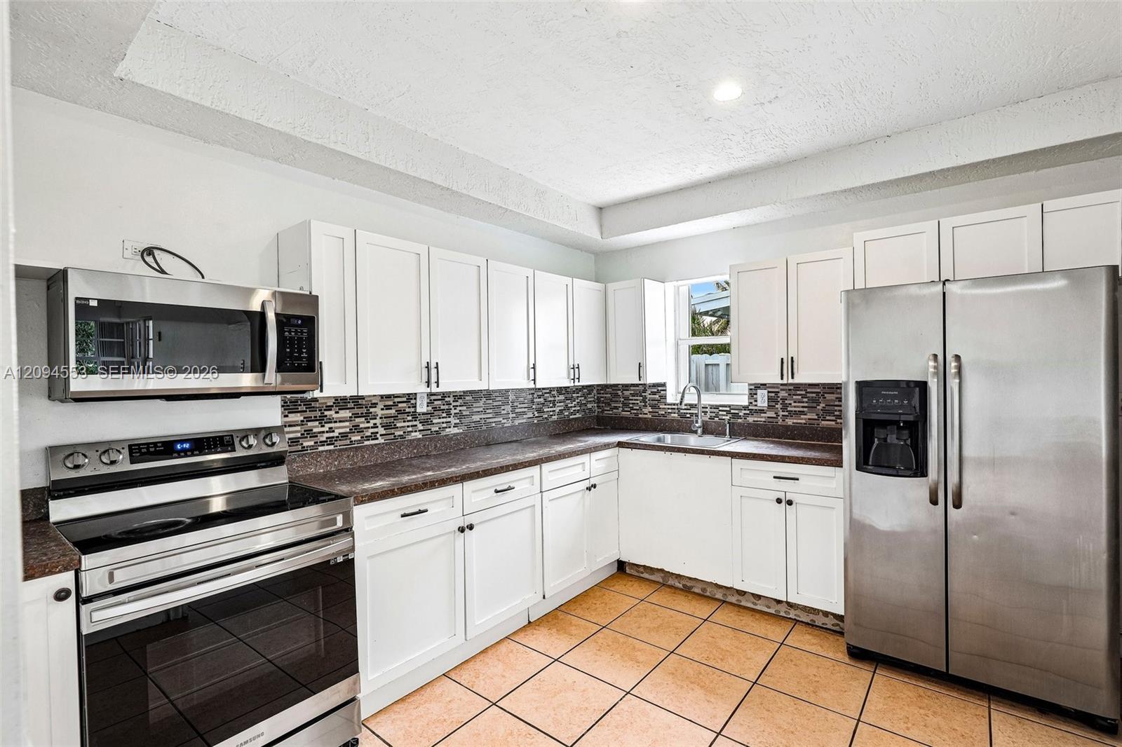 571 Northeast 172nd Street North Miami Beach, FL 33162 - Photo 3 of 33 Kitchen with white shaker cabinets and stainless steel appliances