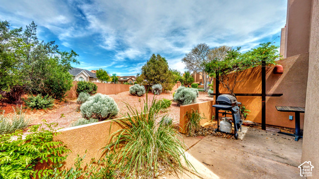 3299 Fairway Loop Moab, UT 84532 - Photo 20 of 23 Paved patio area, stucco exterior wall, and established landscaping with various plant species