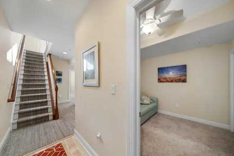 a view of a hallway with stairs and wooden floor