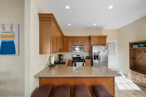 a kitchen with stainless steel appliances granite countertop a sink refrigerator and cabinets