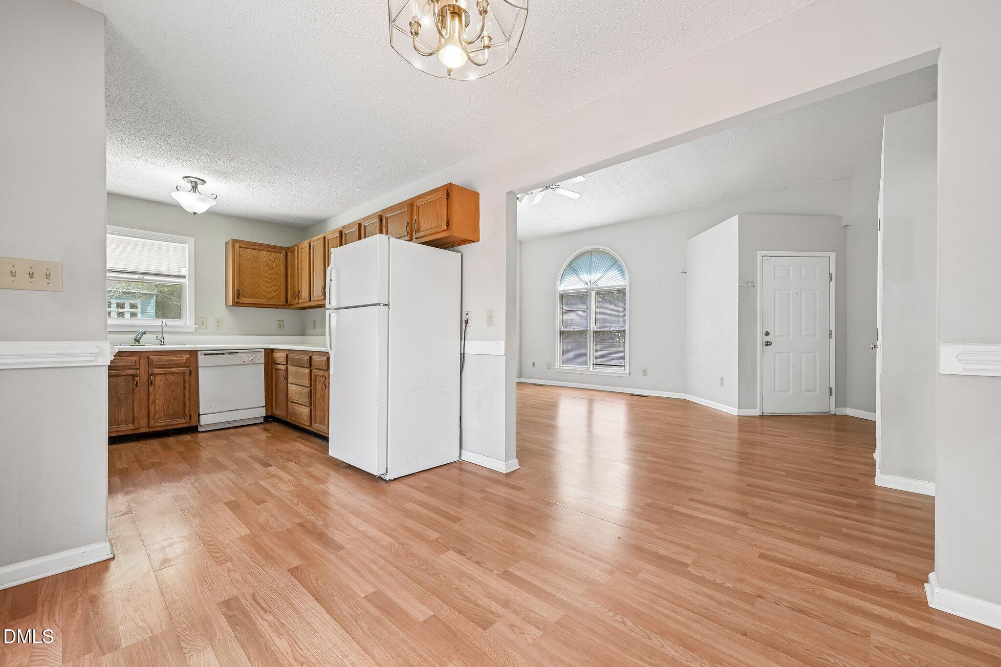 2800 West Jameson Road Raleigh, NC 27604 - Photo 7 of 24 a view of a kitchen with wooden floor and a refrigerator