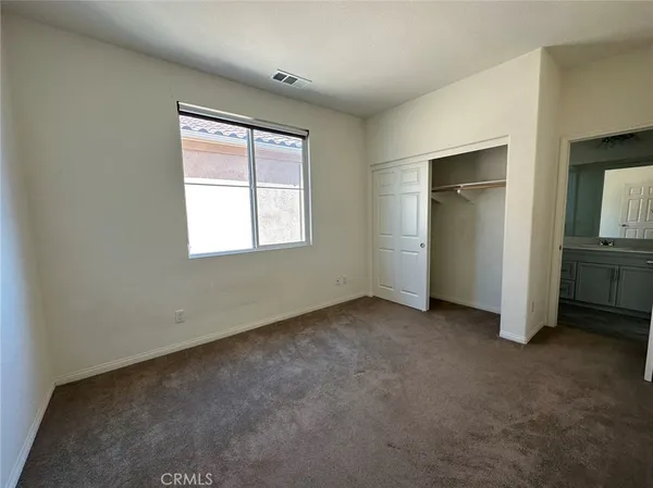 an empty room with closet and windows