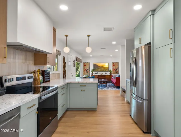 a kitchen with stainless steel appliances a sink stove and refrigerator