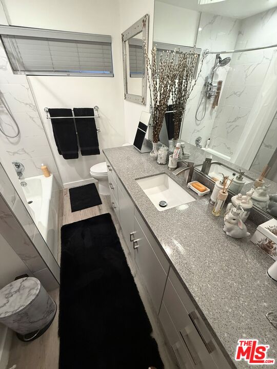 843 4th Street, Unit 207 Santa Monica, CA 90403 - Photo 19 of 49 a bathroom with a granite countertop sink and a mirror