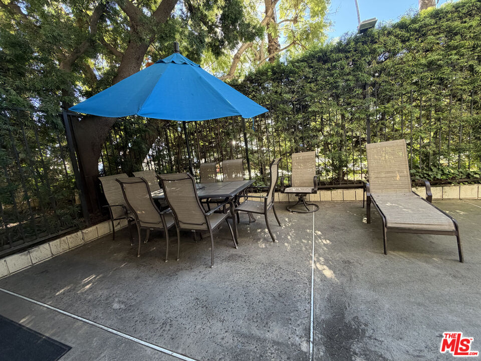 843 4th Street, Unit 207 Santa Monica, CA 90403 - Photo 33 of 49 a view of a patio with chairs and table under an umbrella