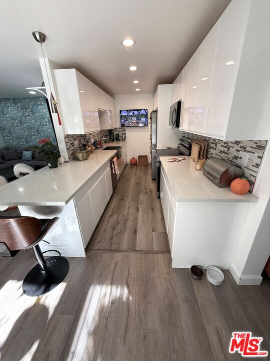 843 4th Street, Unit 207 Santa Monica, CA 90403 - Photo 6 of 49 a large white kitchen with wooden floors