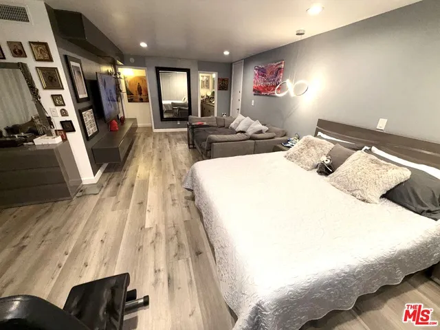 a bedroom with a bed and wooden floor