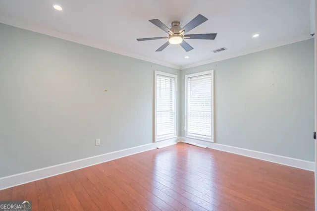 an empty room with a window and a ceiling fan