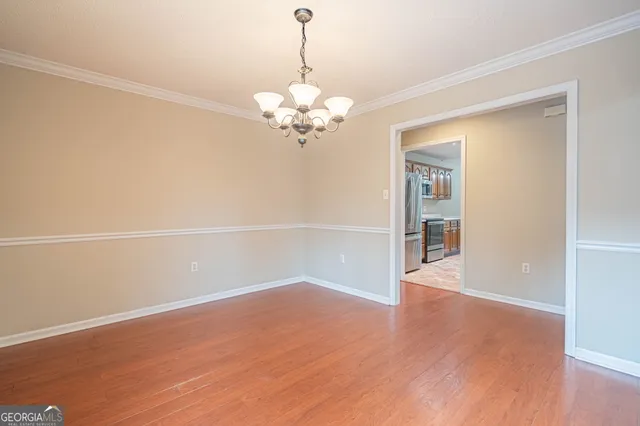 a view of a room with wooden floor and chandelier
