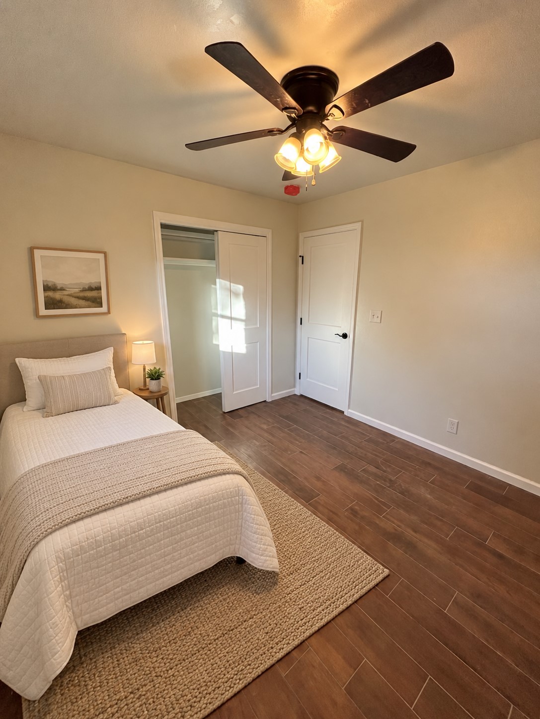 900062 South 3320 Road Wellston, OK 74881 - Photo 6 of 11 Comfortable bedroom showcasing wood-finish flooring, ceiling fan with integrated lighting, and neutral wall finishes