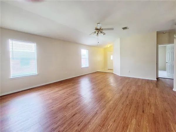 a view of a room with wooden floors and ceiling fan
