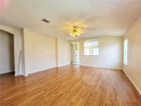 an empty room with wooden floor and window