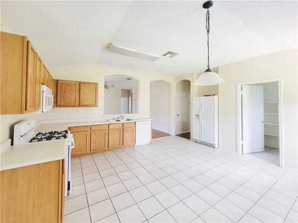 a view of a kitchen with a sink a refrigerator and a counter top space