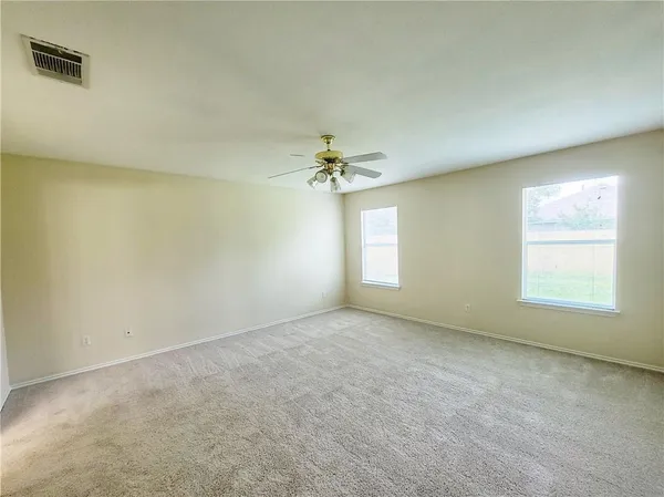 an empty room with a window and a ceiling fan
