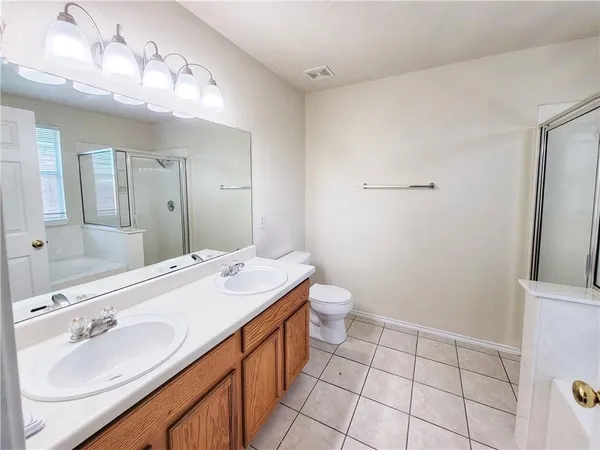 a spacious bathroom with a sink a toilet a mirror and vanity