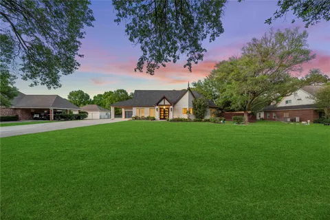 an aerial view of a house with a yard and lake view