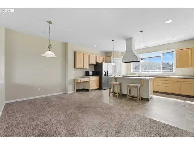 a kitchen with stainless steel appliances granite countertop a sink a stove and a refrigerator