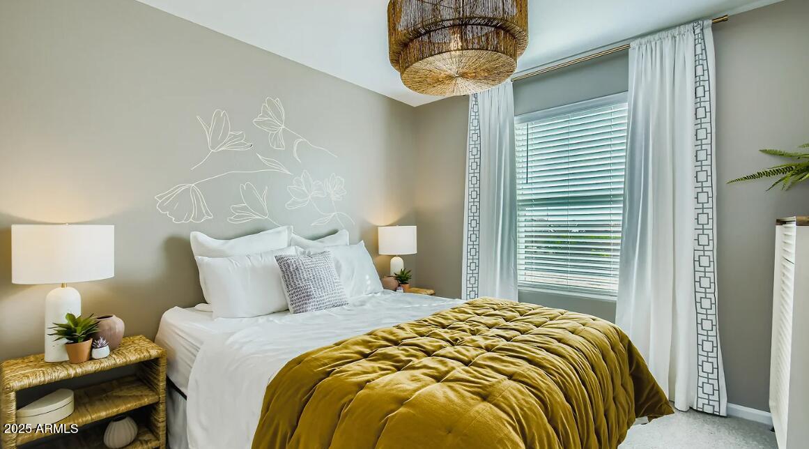 9553 West Verde Lane Phoenix, AZ 85392 - Photo 17 of 24 a bedroom with a bed and a chandelier