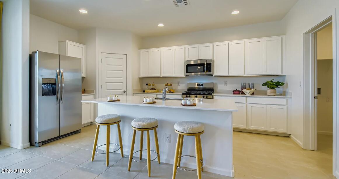 9553 West Verde Lane Phoenix, AZ 85392 - Photo 2 of 24 a kitchen with refrigerator and cabinets