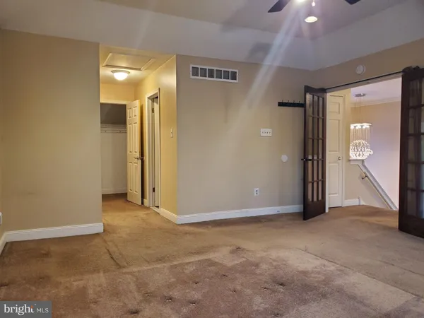 an empty room with closet and mirror