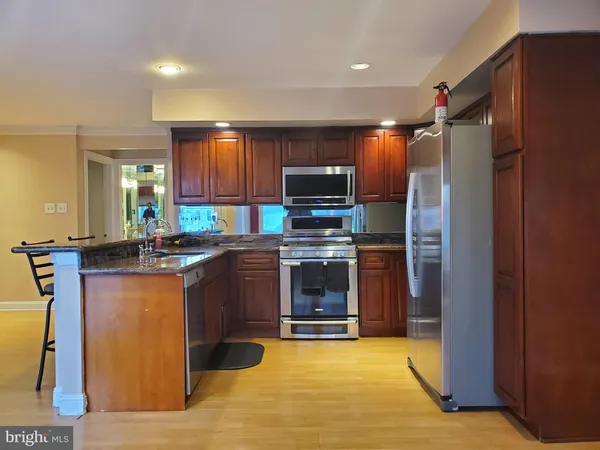 a kitchen with stainless steel appliances granite countertop a refrigerator a sink and a stove