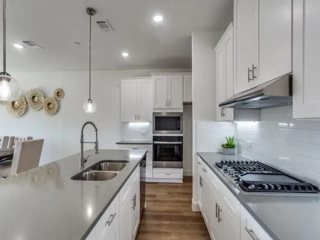 a kitchen with kitchen island a sink stove top oven and cabinets