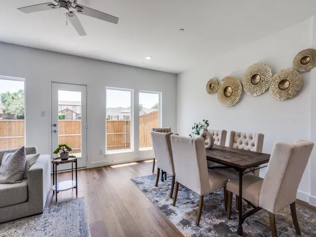 a view of a livingroom and a dining room with furniture window and wooden floor