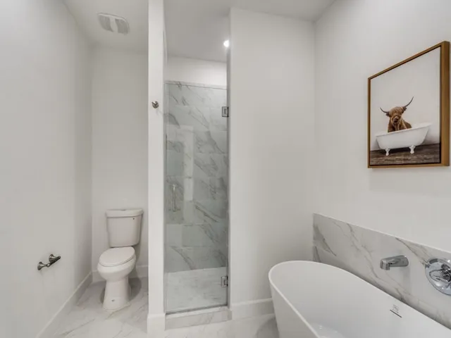 a bathroom with a toilet a sink and shower