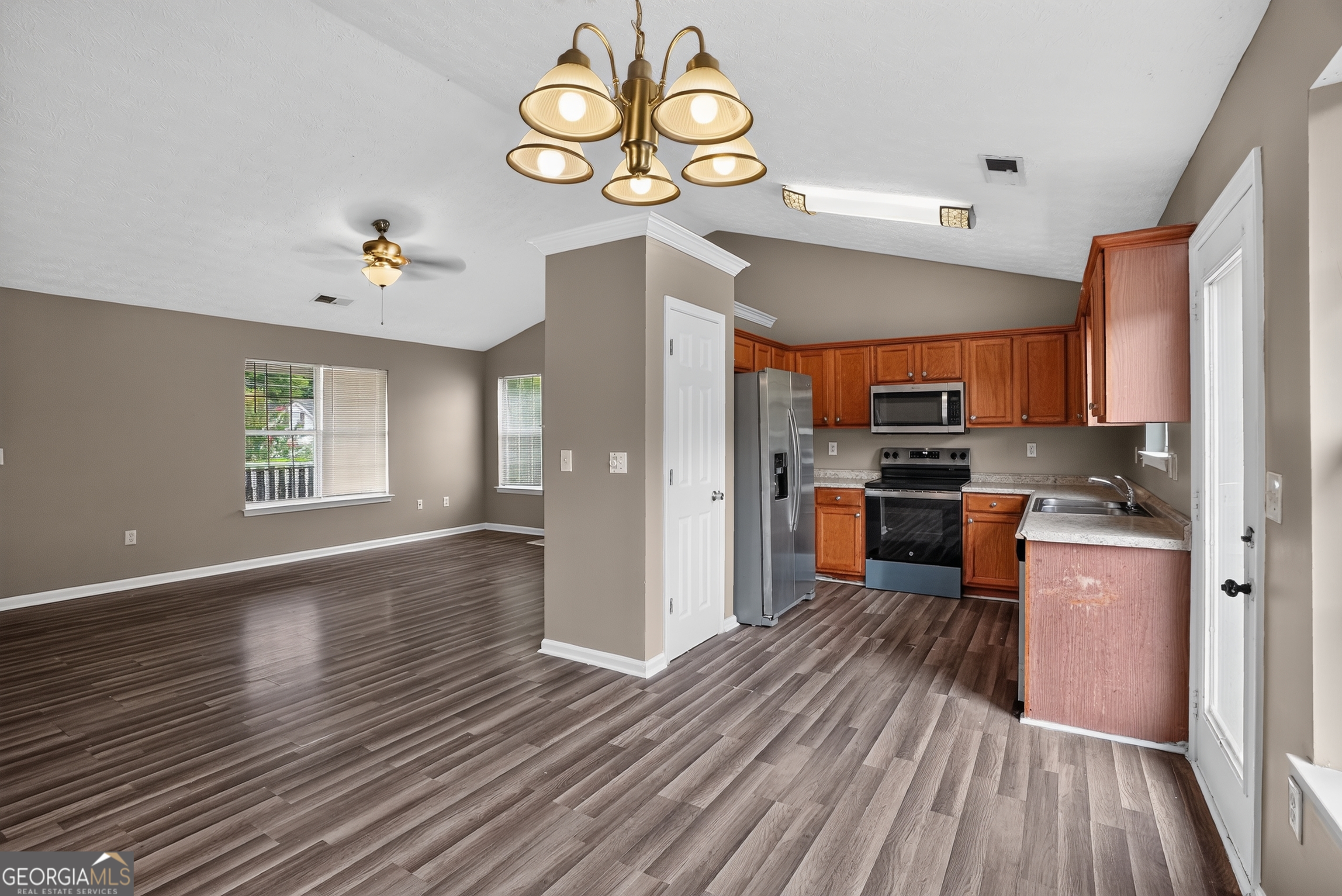 75 Linsley Way Covington, GA 30016 - Photo 25 of 48 a kitchen with stainless steel appliances a refrigerator oven a stove top oven and wooden floors