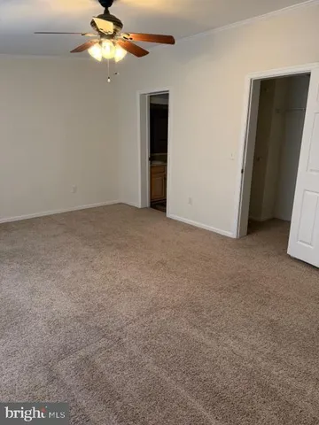 a view of a big room with closet and a chandelier fan