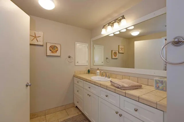 a bathroom with a granite countertop sink mirror and vanity