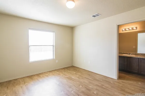 an empty room with cabinet and windows