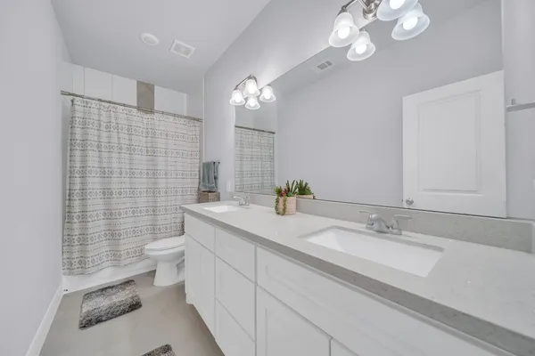 a bathroom with a sink double vanity granite and a mirror