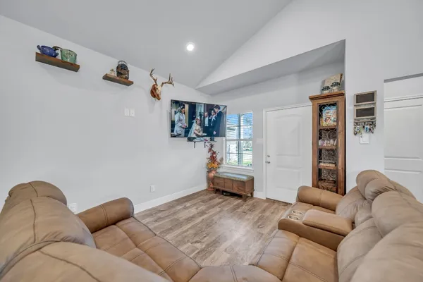a view of a dining room with furniture a kitchen and chandelier