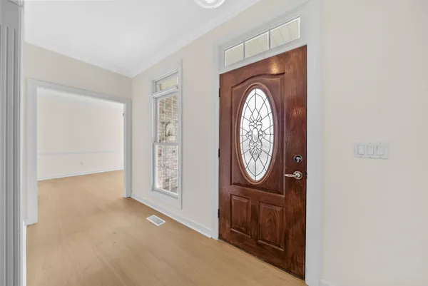 a kitchen with stainless steel appliances granite countertop a stove top oven a sink dishwasher and white cabinets with wooden floor