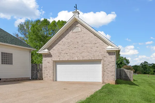 a front view of a house with a yard and potted plants